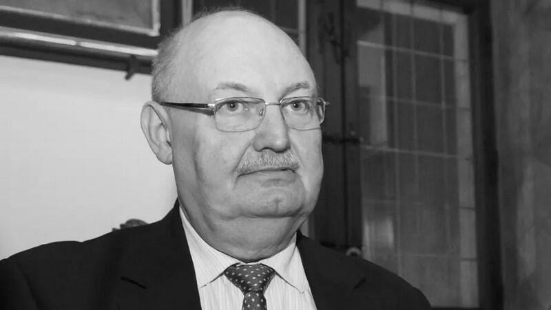 Czarno-białe zdjęcie. Twarz starszego łysawego mężczyzny w okularach