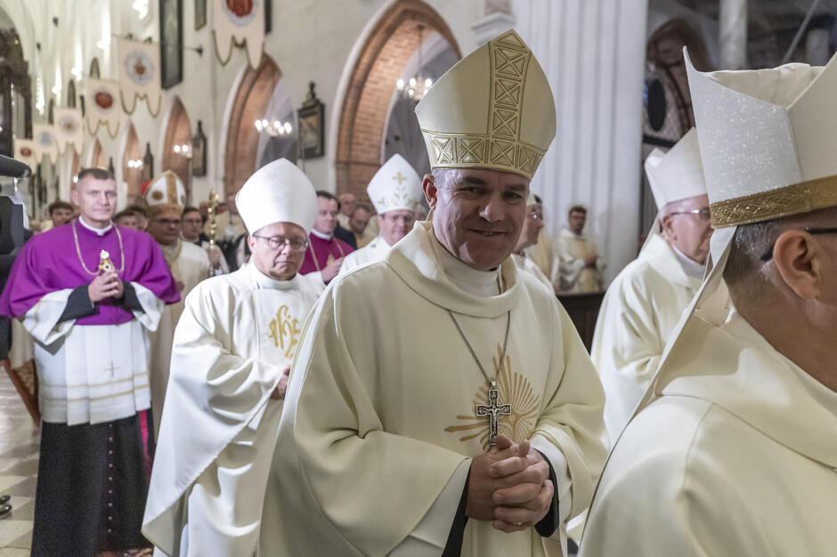 Kilku biskupów idzie gęsiego środkiem kościoła - wśród nich arcybiskup Zieliński 
