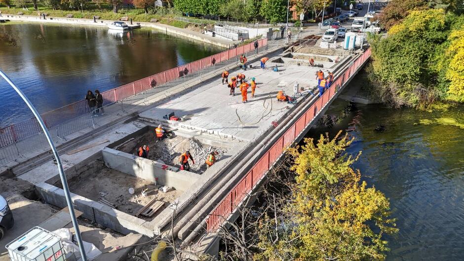zdjęcie z drona, widać remontowany betonowy most, są elementy budowlane i robotnicy