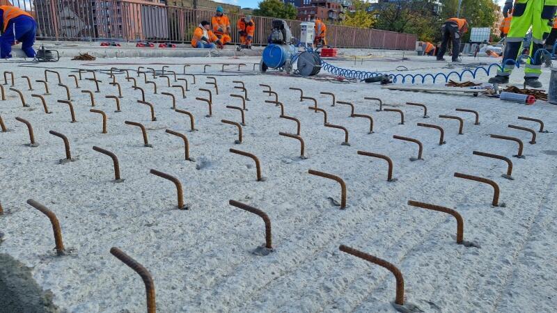 zbliżenie na betonowy element mostu z którego wystają metalowe pręty