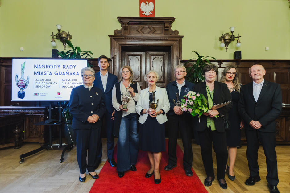 Grupowe zdjęcie wykonane w dużej zabytkowej sali