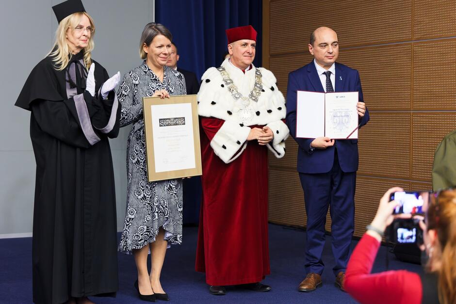 Cztery osoby na scenie pozują do zdjęcia