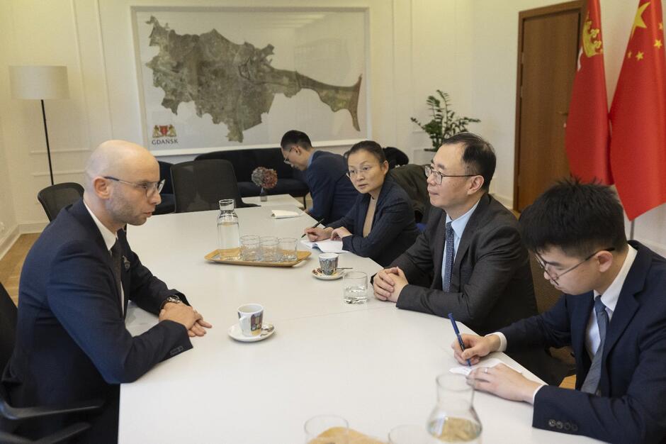 Kilka osób podczas dyskusji przy stole w gabinecie