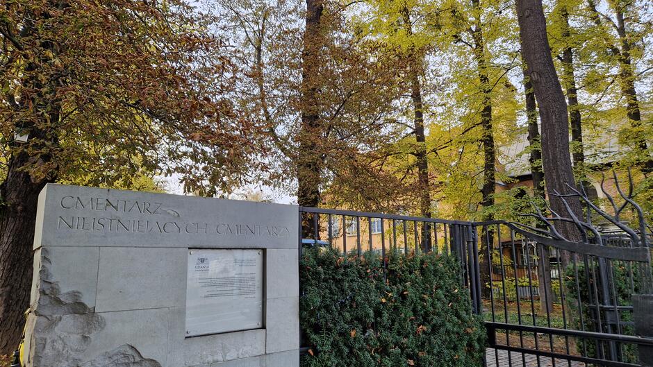 Kamienna płyta przy bramie. Na płycie napis Cmentarz Nieistniejących Cmentarzy