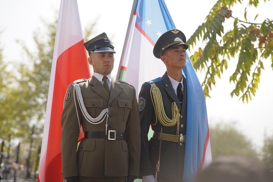 Dwaj żołnierze na tle flag narodowych