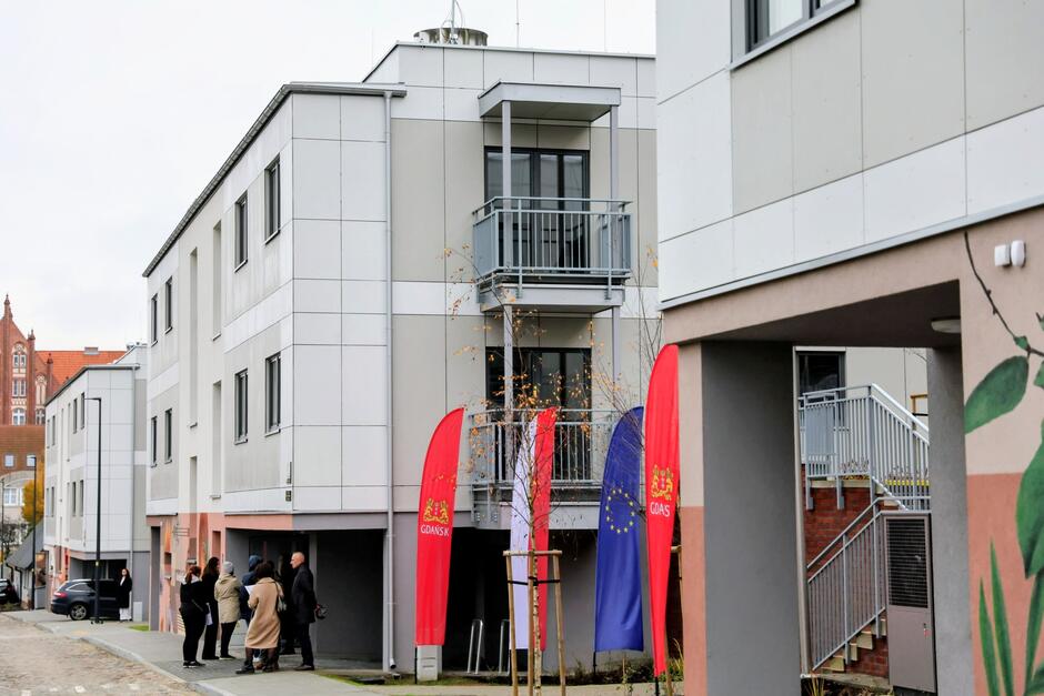 na zdjęciu dwa szaro białe nowe budynki mieszkalne