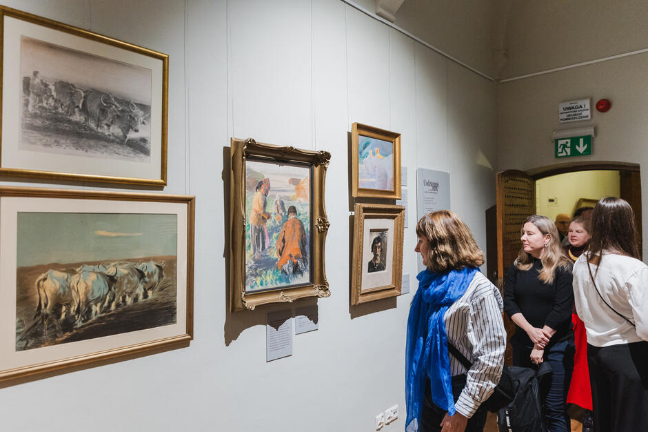 Ludzie zwiedzają wystawę malarstwa.