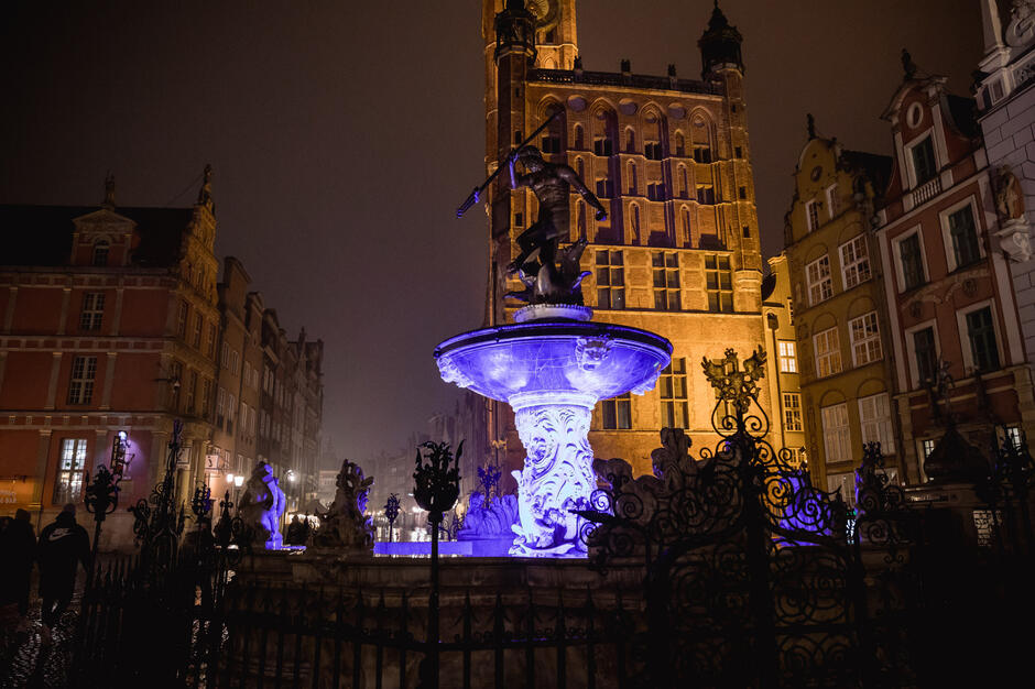 Fontanna Neptuna w Gdańsku podświetlona na fioletowo.