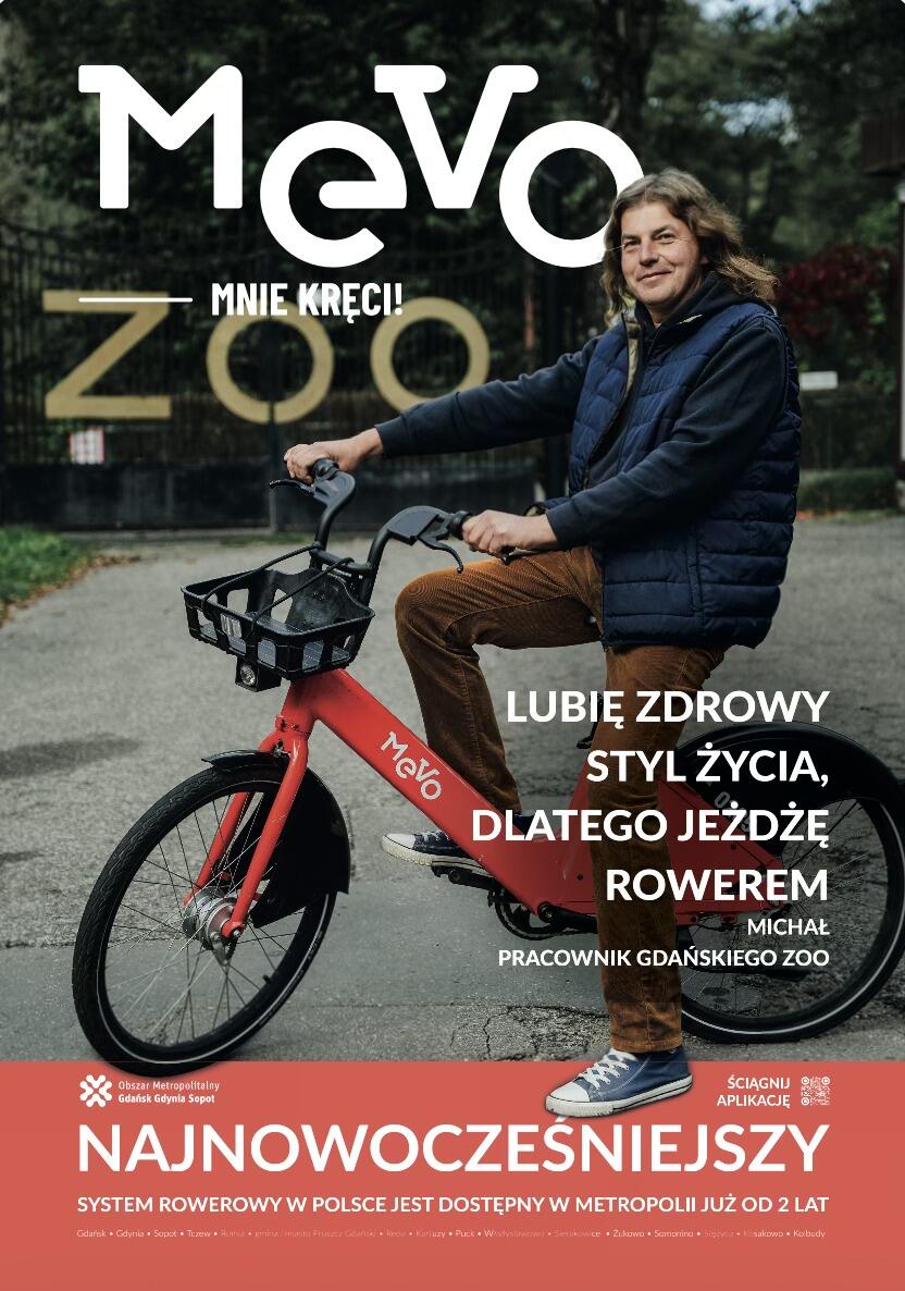 Na plakacie widać mężczyznę siedzącego na czerwonym rowerze miejskim Mevo, ustawionego na tle wejścia do zoo. Grafika promuje zdrowy styl życia i korzystanie z systemu rowerów miejskich, podkreślając nowoczesność rozwiązania dostępnego w metropolii. 