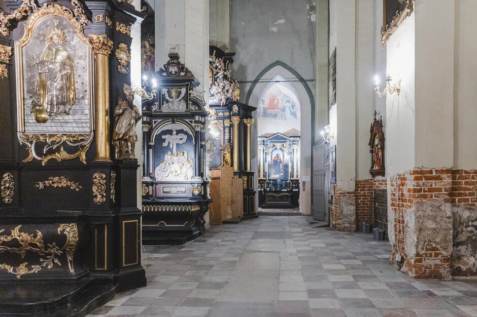 wnętrze kościoła w perspektywie, widoczne malowidła na ścianie i drewniany wystrój