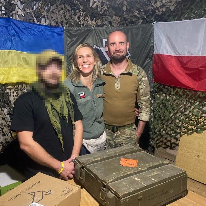 Trzy osoby pozują do zdjęcie. Kobieta pośrodku. Mężczyzna po lewej ma zapikselowaną twarz