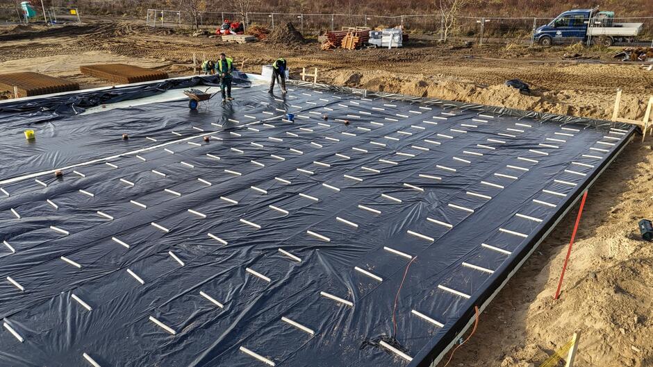 na zdjęciu czarna folia rozłożona na gruncie