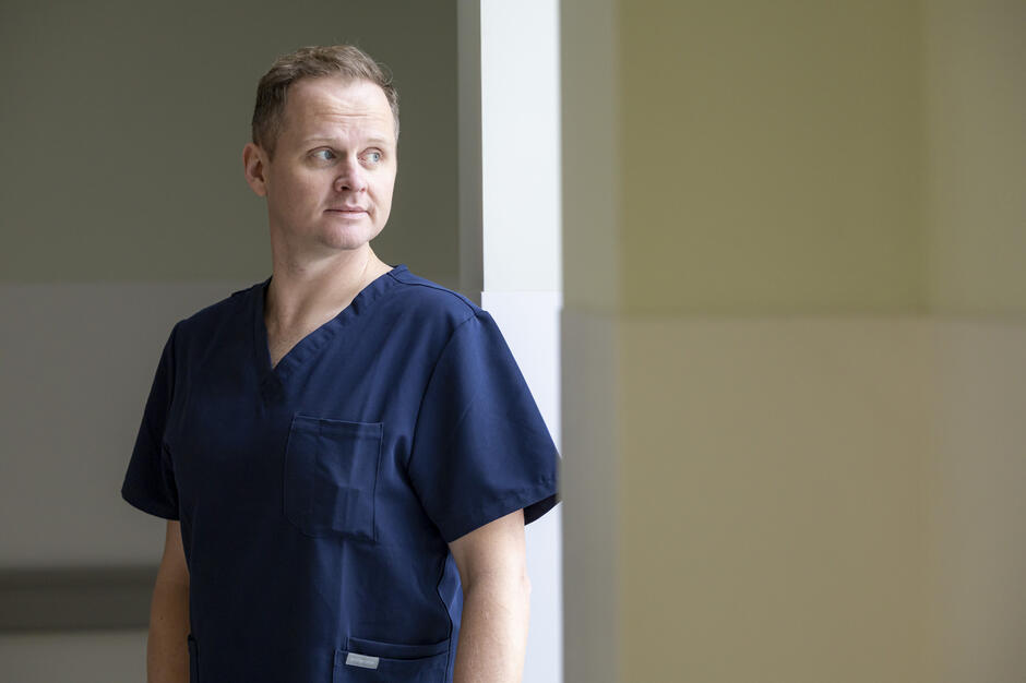 mężczyzna w lekarskim kitlu patrzy w okno