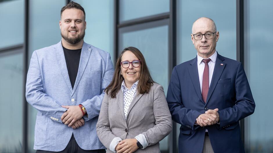 Trzy osoby wspólnie pozują do zdjęcia