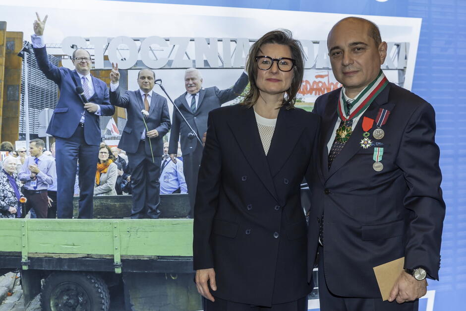 Dwie osoby pozują do zdjęcia - kobieta z lewej, mężczyzna z prawej