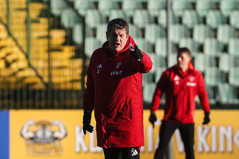 Mężczyzna w czerwonym sportowym dresie wydaje polecenia na treningu