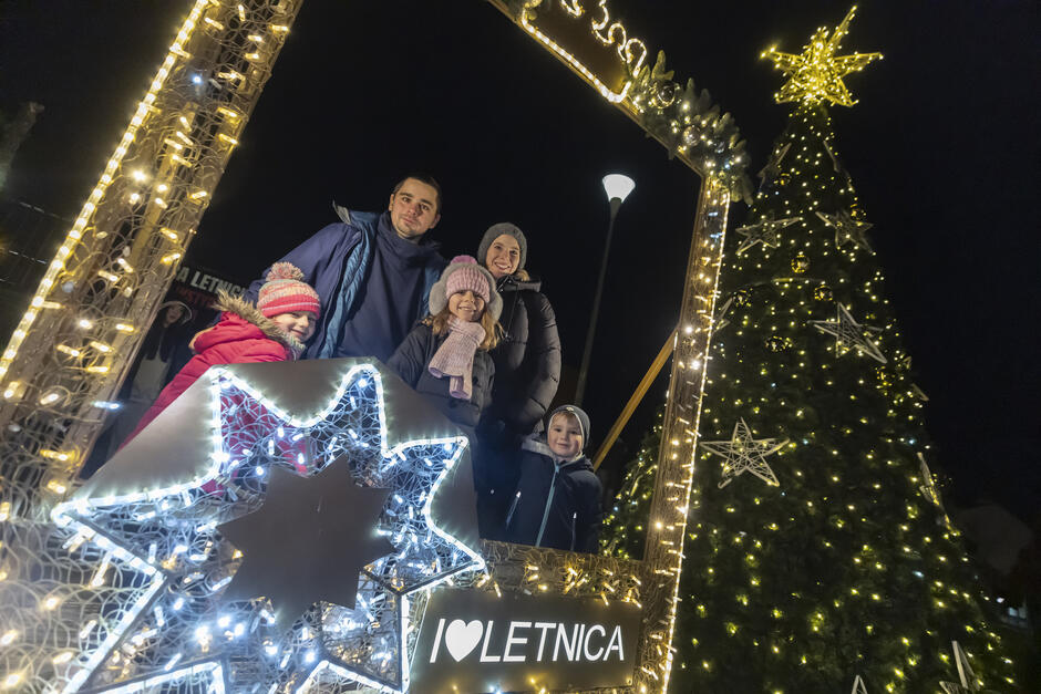 Rodzina pozuje do zdjęcia stojąc w ramie