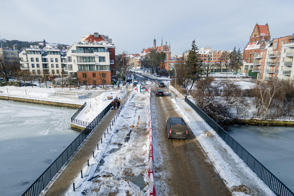zdjęcie z drona, widać odnowiony most po którym jedzie samochód, w tle budynki róznej wielkości