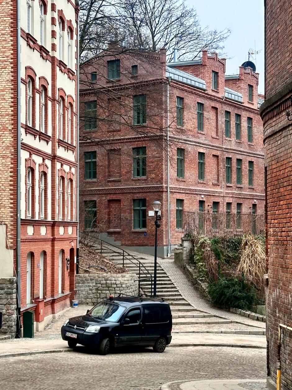 Samochód na zakręcie Biskupiej Górki. W tle odnowione kamienice.