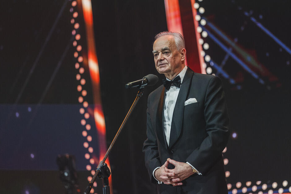 starszy mężczyzna przemawia do mikrofonu