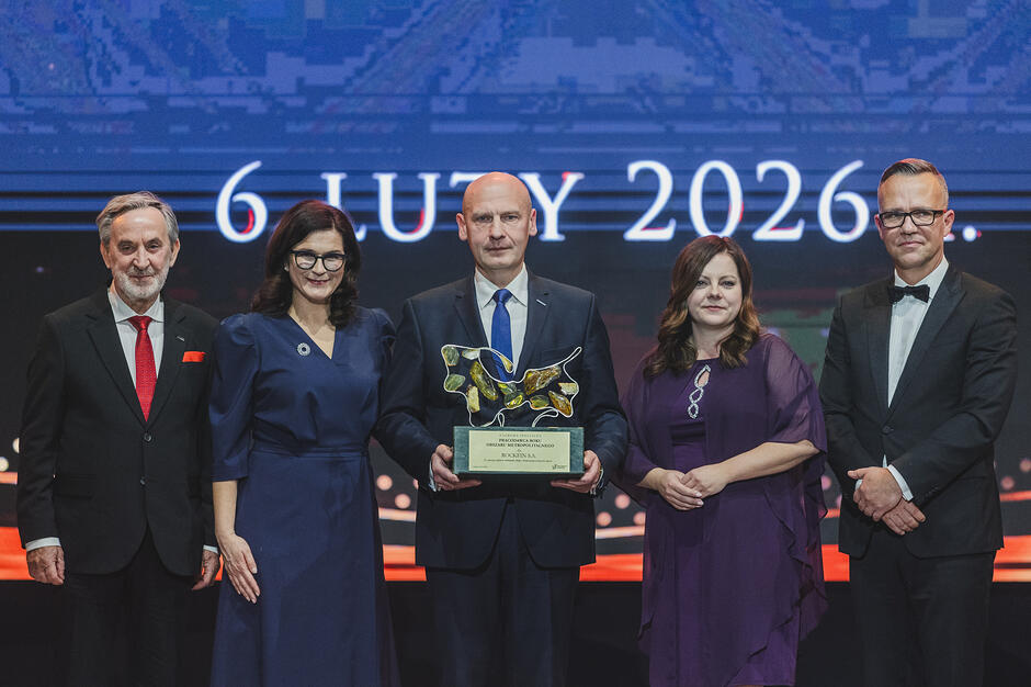 wymienione osoby stoją rzędem na scenie