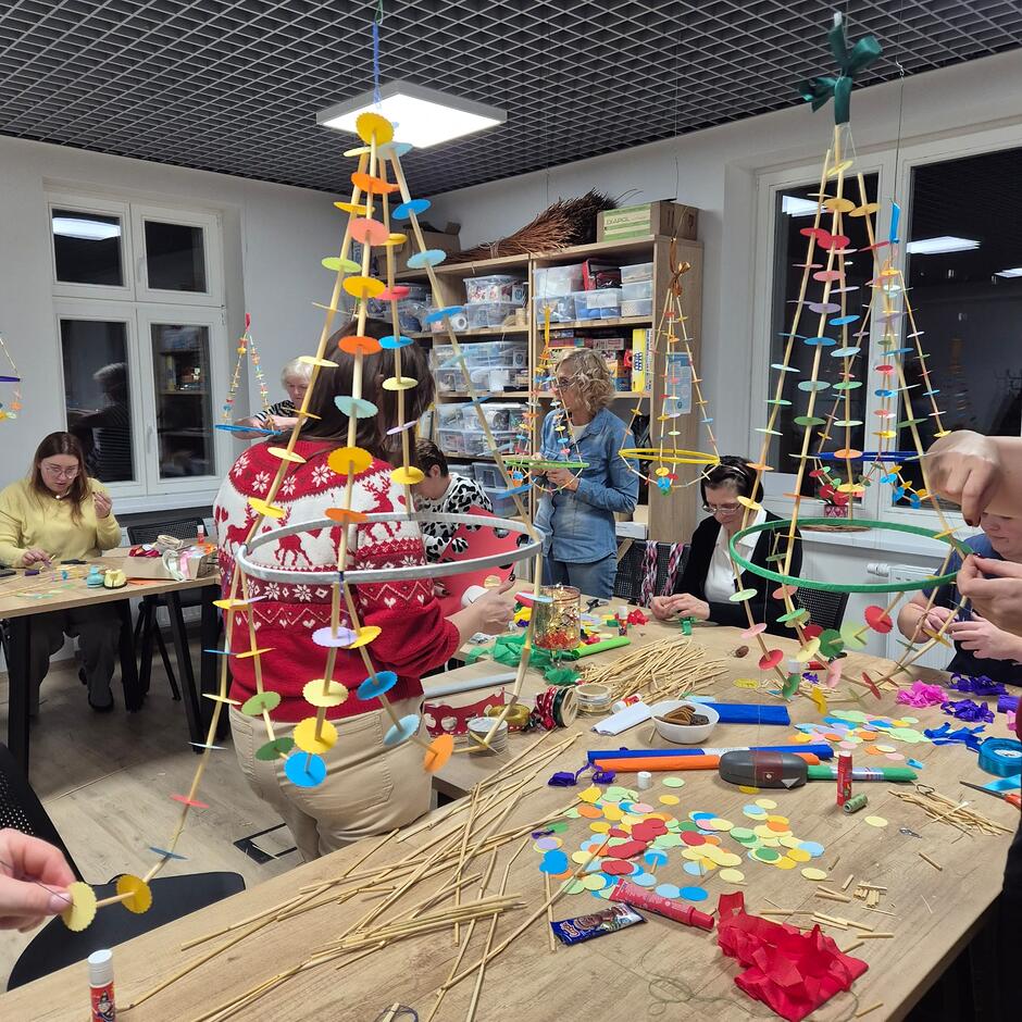 Na dużych stołach tworzone są duże papierowe ozdoby bożonarodzeniowe, tzw. pająki 