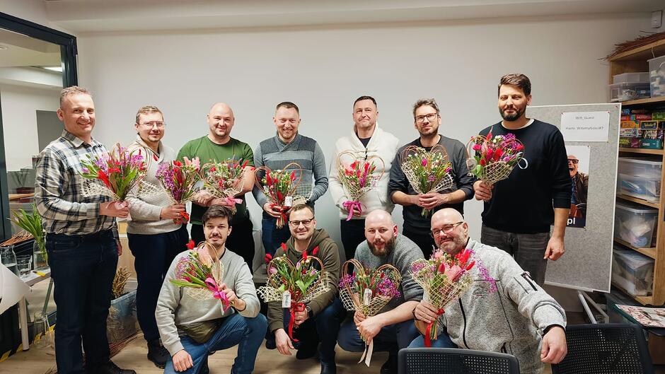 Jedenastu mężczyzn z kompozycjami kwiatów w wiklinowych serduszkach