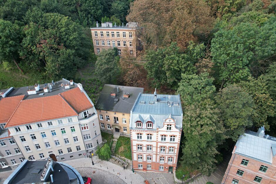 Widok z góry na kamienice przy ulicy zakręcającej w górę