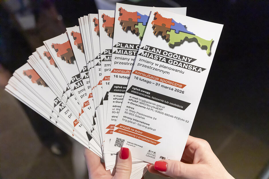 ręka trzymająca stos broszur. Informują one o konsultacjach w sprawie Planu Ogólnego Miasta Gdańska