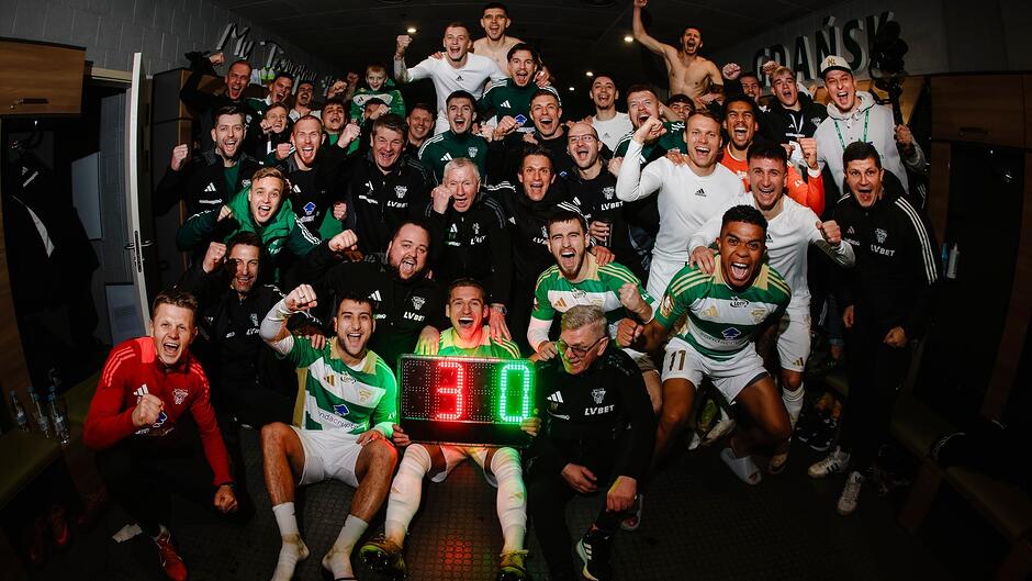 Grupa 30 mężczyzn w euforii - na tablicy wynik 3:0