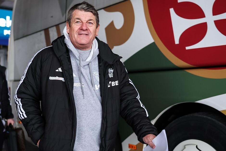 Trener obok klubowego autokaru