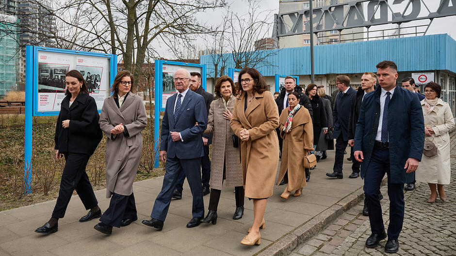 grupa osób w oficjalnych strojach idą przed siebie