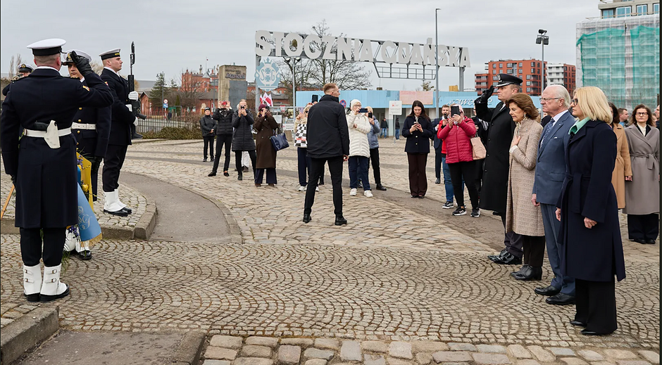 grupa osób oddaje hołd pod pomnikiem, są tam też marynarze w oficjalnych mundurach