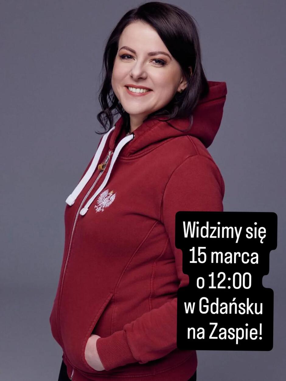 Zdjęcie uśmiechniętej Kai Godek w czerwonym dresie sportowym z godłem przedstawiającym orzełka RP 