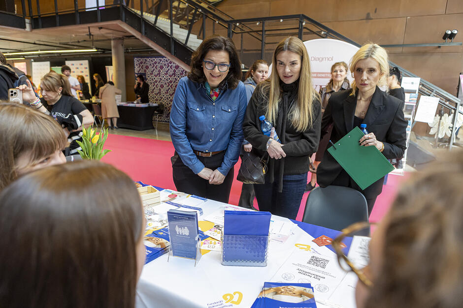 Gdański Kongres Zdrowia Kobiet w Europejskim Centrum Solidarności. Przy jednym ze stoisk kobiety wspierające zdrowie: Aleksandra Dulkiewicz - prezydentka Gdańska, Dominika Jaśkowiak z Fundacji Medea oraz Hanna Lis - dziennikarka.