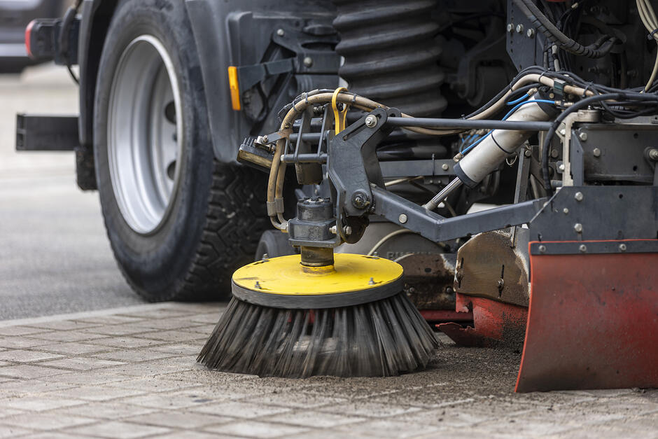 na zdjęciu duża okrągła szczotka przymocowana do samochodu, służąca do sprzątania ulicy