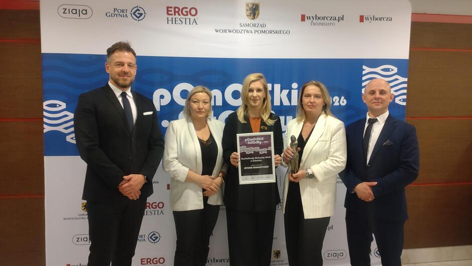 Pięć eleganckich osób - trzy kobiety i dwóch mężczyzn ze statuetką Pomorskie Sztormy i dyplomem