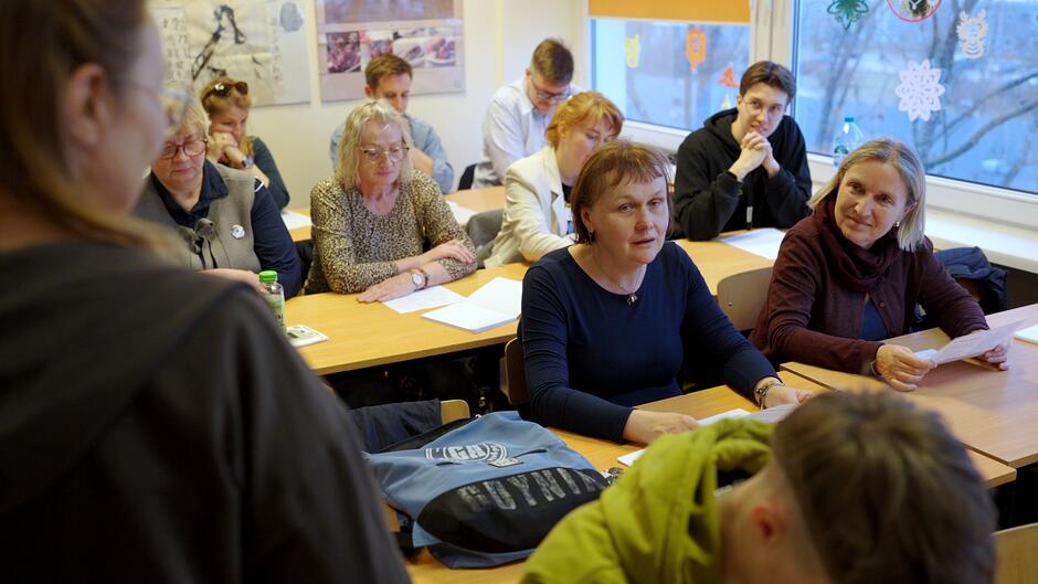 Ludzie siedzący w ławkach szkolnych