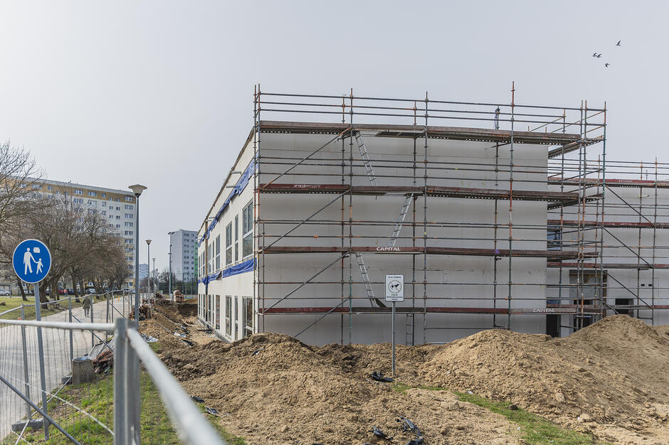 na zdjęciu budowany dwukondygnacyjny szary budynek