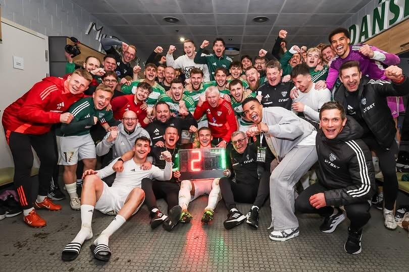 Grupa około 30 rozradowanych mężczyzn, ustawiona do grupowego zdjęcia