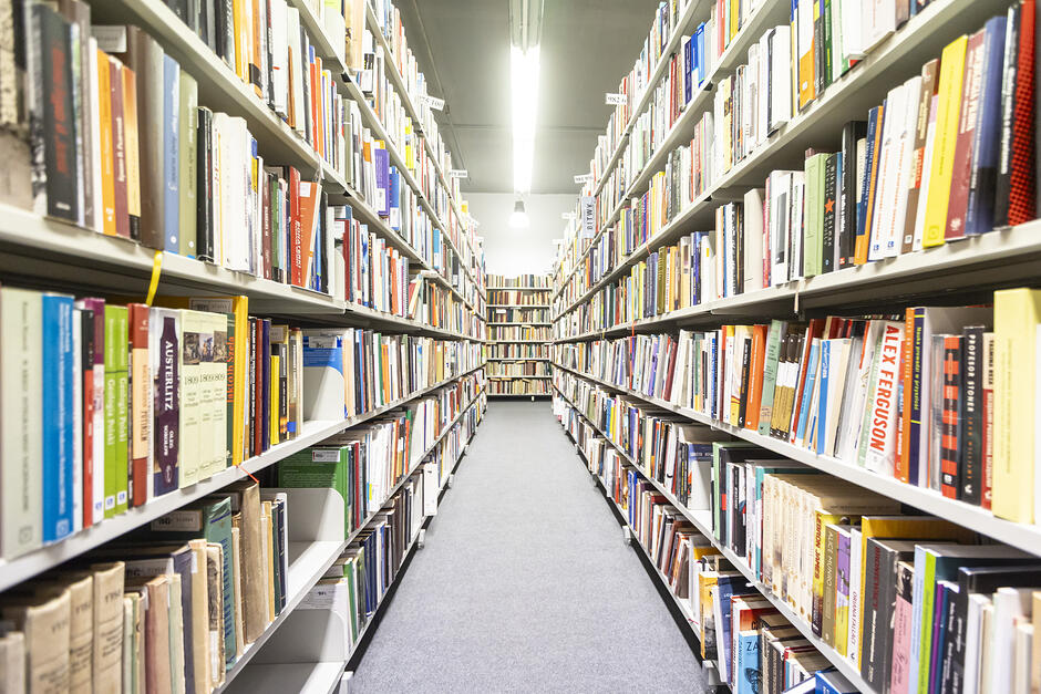 na zdjęciu regały w bibliotece wypełnione po brzegi książkami