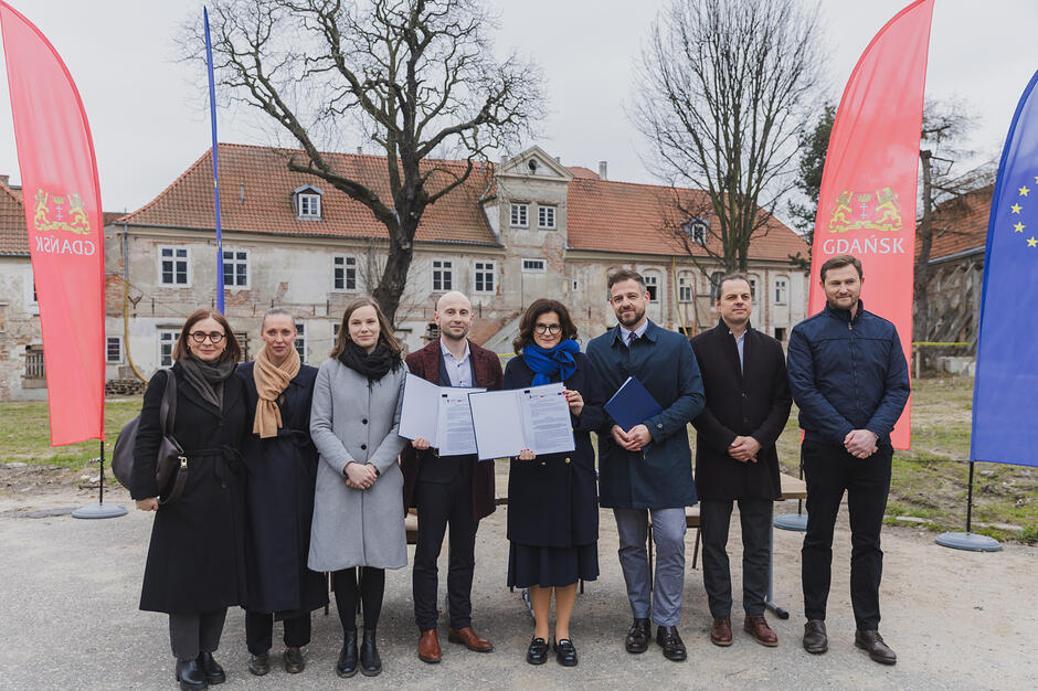 na zdjęciu dziesięć dorosłych osób w ciepłych ubraniach pozuje w jednym rzędzie do zdjęcia