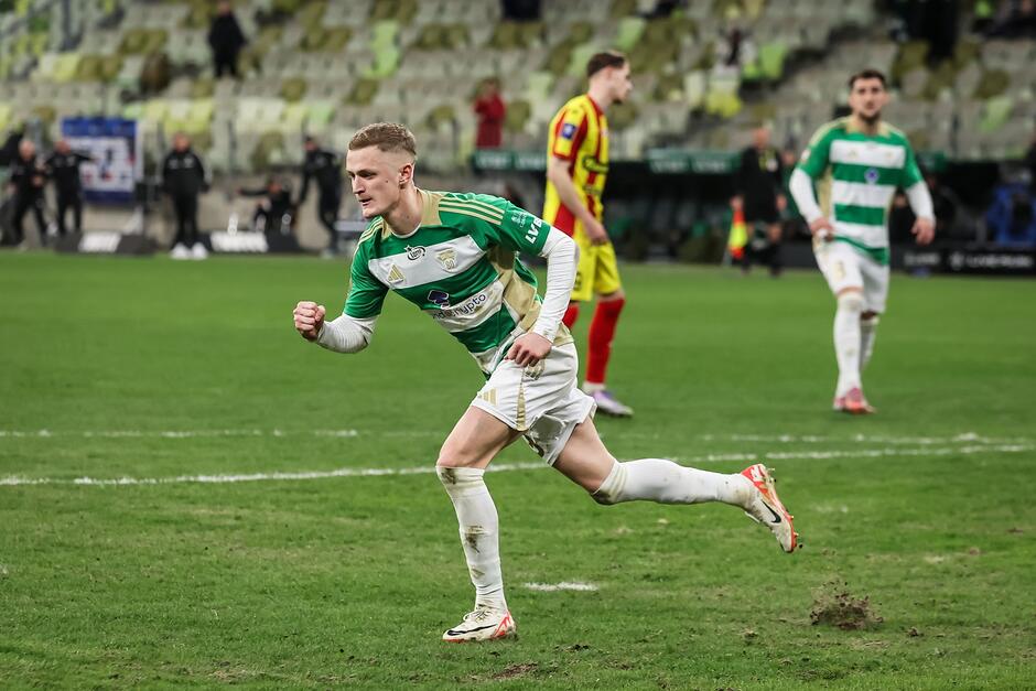 Zawodnik na boiska, w tle widać innych zawodników obu drużyn