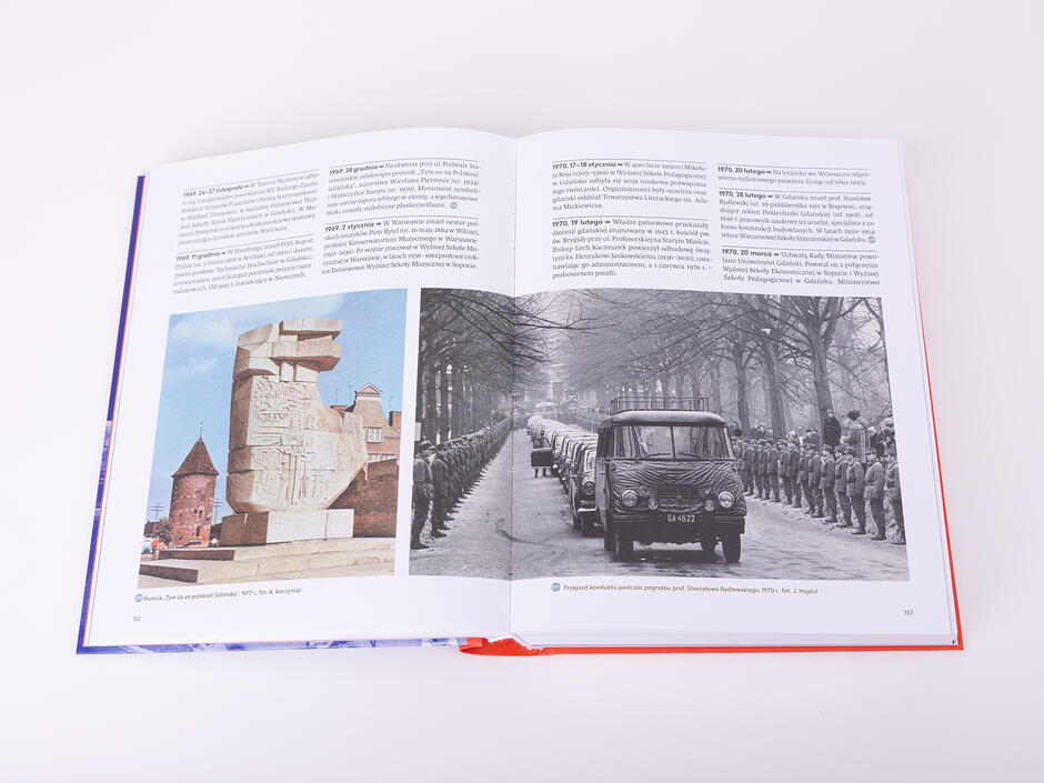 Otwarta gruba księga sfotografowana w studiu fotograficznym na jasnym tle. W otwartej księdze widać archiwalne zdjęcia miasta.