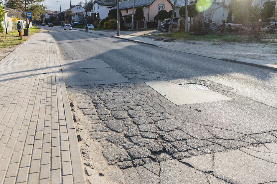 na zdjęciu zniszczona nawierzchnia asfaltowa jezdni