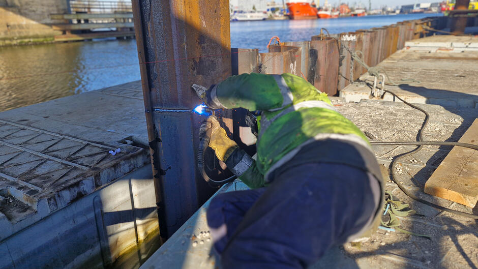 na zdjęciu robotnik spawa metalowe elementy ścianki szczelnej mostu