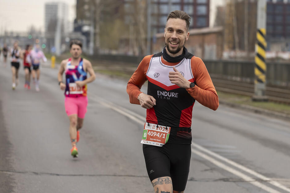 Biegacz lat około 35 - na trasie maratonu