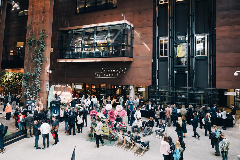 Tłum ludzi w hallu wielkiego, nowoczesnego budynku.