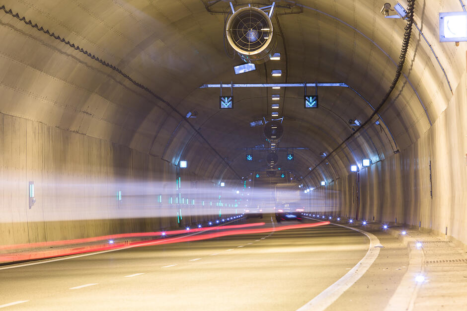 Tunel drogowy, z rozmytymi światłami jadących samochodów.