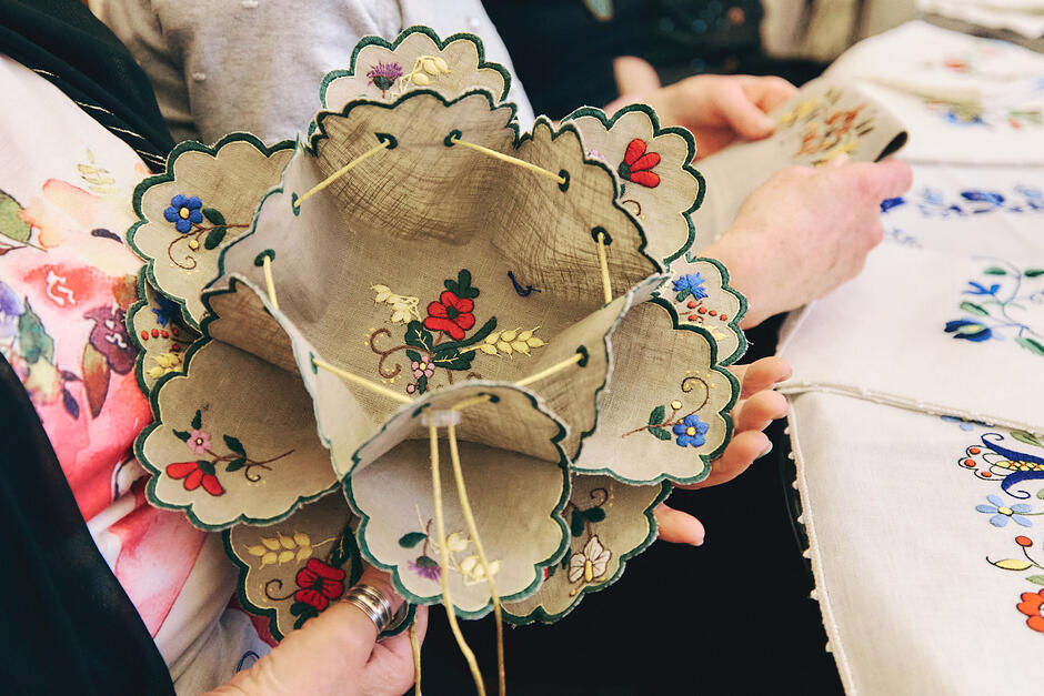 Kobieta trzyma w rękach hafty